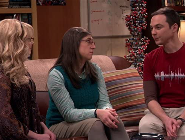 Bernadette, Amy, and Sheldon on a couch.