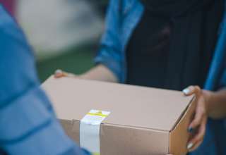 A woman accepting her delivery from a courier.