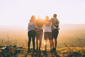 Friends watching sunset. Photo by Helena Lopes via Unsplash