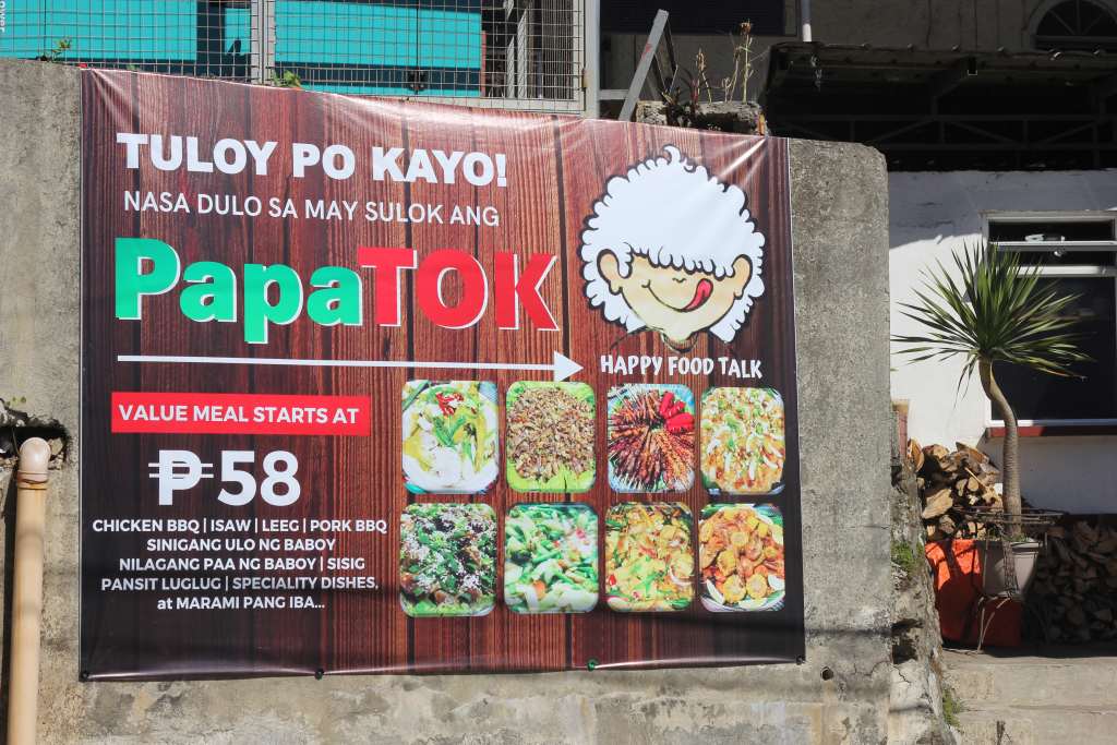 PapaTok’s tarpaulin and their signature dishes. Photo by Mikaela Bello.